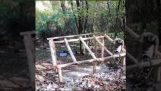 Construcción de una cabaña de troncos con herramientas manuales.