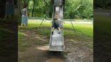 Child on a slide against a puddle