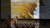 Pisică care încearcă să prindă un pește la televizor