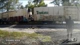 Et tog treffer semi-trailer fast på jernbane