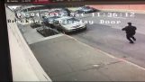हथकड़ी आदमी पुलिस कार से बाहर हो जाता है और भागने की कोशिश करता है
