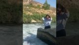 A menina deixa cair seu telefone no rio