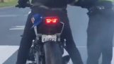 Симпатичен полицай помага на мотоциклетист да направи бърнаут
