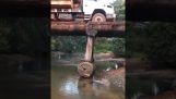 Um caminhão carregado de madeira em uma ponte de madeira