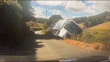 A garbage truck overturns in a field