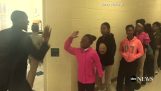 Lærer gør separate håndtryk med hver elev
