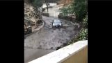 Bil gjør vannski på oversvømte veien
