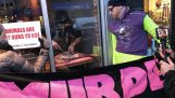 restaurant owner cuts of meat in front of vegan protesters