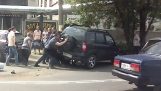 Rettungsmotorradfahrer unter Auto stecken