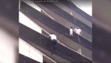Unge klatring en balkon for at redde et lille barn