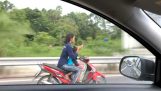 Mother on motorcycle is texting while driving