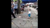 A toddler defends his grandmother with a metal tube