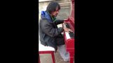 Бездомните човек свири музика, композирана от себе си на пианото