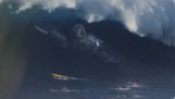 A giant wave “swallows” surfers
