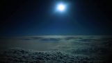 Flygande ovan molnen i månskenet