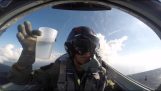 पायलट एक गिलास पानी पी रहा है, जबकि उल्टा लड़ाकू विमान के साथ उड़ान