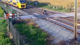 นักขี่จักรยานหนีออกมาสั้น ๆ จากรถไฟที่ข้ามทางรถไฟ