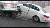 Conductor intenta tirar de su coche por la grúa (Rusia)