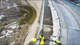 Biker teeters op de leuning van een dam