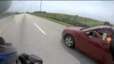 راكب دراجة بخارية مطاردا من قبل سائق سيارة