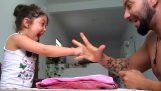 A dad playing rock-paper-scissors with his daughter