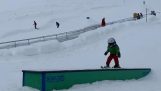 Een kind doet de truc “skiën met het hoofd”