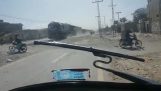 Motorrijder heeft haast om de treinsporen over te steken (Pakistan)