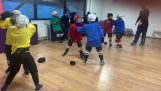 Un allenatore di hockey mostra ai bambini come prendere a pugni