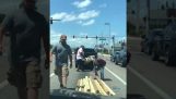 Motorists help an elderly man who has lost his load