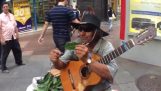 Уличный музыкант имитирует звук трубы на листе