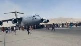 Afganos intentan abordar un avión que despega en el aeropuerto de Kabul