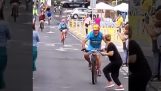 Åskådare hukar med en cyklist