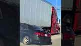 Truck travels with car under its trailer
