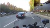 Een politieagent op een motorfiets maakt de weg vrij voor een ambulance
