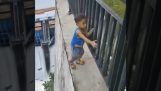 Ouder neemt zijn kind op op de muur van een dam