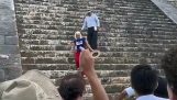 En turist klättrar upp i pyramiden i Kukulcán