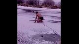Ein Mann rettet einen Hund in der Mitte von einem gefrorenen Fluss